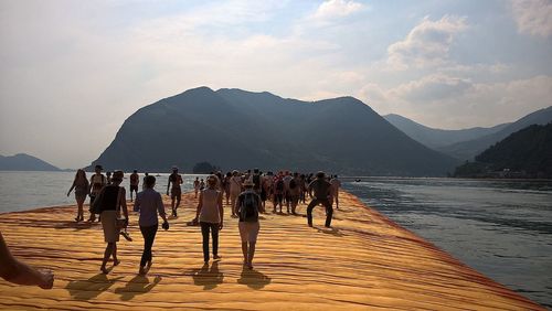 Panoramic view of people on beach against sky