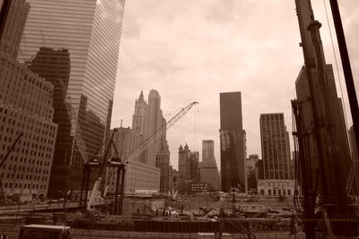 Modern buildings in city against cloudy sky