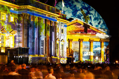 Group of people in front of illuminated building at night