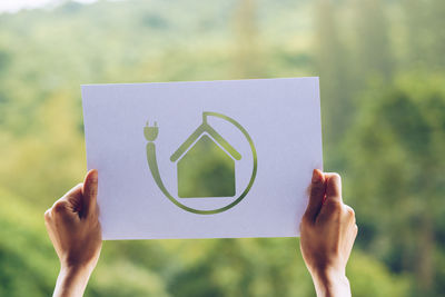 Cropped hand of woman holding paper outdoors