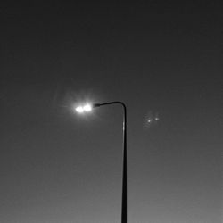 Low angle view of illuminated street light against sky
