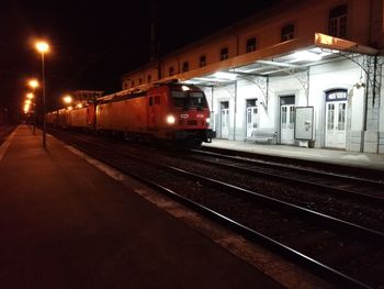 Train at railroad station platform at night