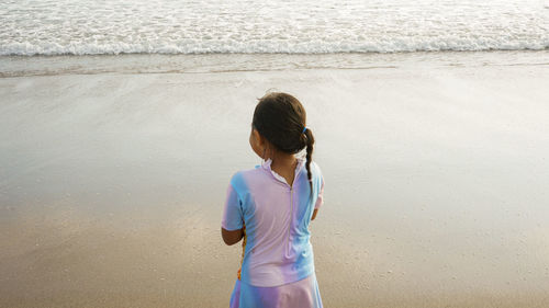 A little girl is playing on the beach