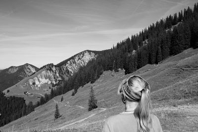 Rear view of woman looking at mountains against sky