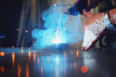 Close-up of hand holding illuminated lighting equipment