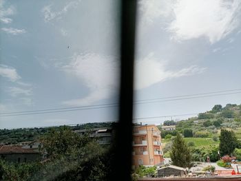 Buildings against sky seen through glass window