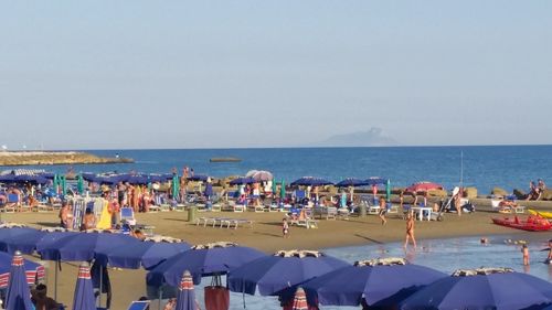 Panoramic view of people on beach against clear sky