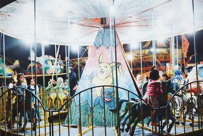 People at amusement park ride at night