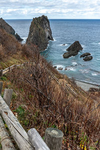Rocks on sea shore against sky