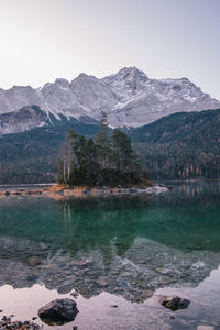 Scenic view of lake by snowcapped mountains against sky