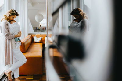 Mother carrying newborn son at home