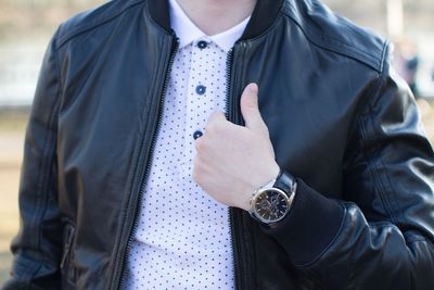 Midsection of man wearing leather jacket