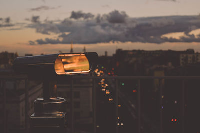 Close-up of beer on building against sky at sunset