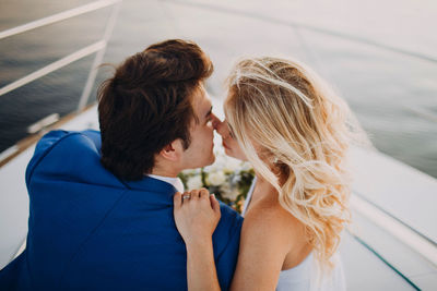 Couple kissing while sitting on boat