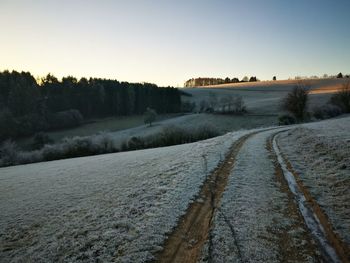 Scenic view of landscape against clear sky during winter