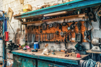 Vintage workshop. antique tools hang on wall, repair equipment on the table. side view.