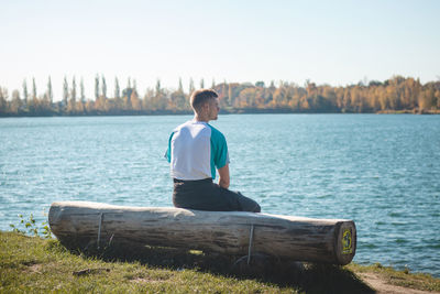 Young athlete relaxes and meditates on a wooden bench at lake kalisovo, ostrava, czech republic