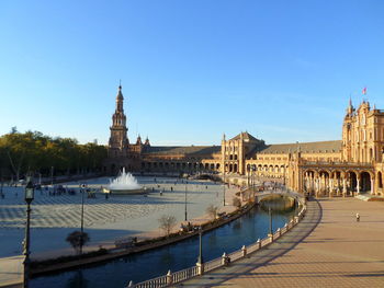 View of canal and buildings against blue sky