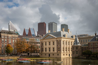 Buildings in city against cloudy sky