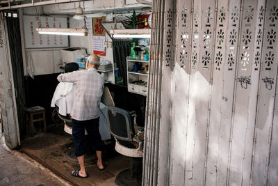 Rear view of man standing at entrance of building