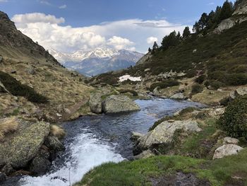 Scenic view of river and mountains against sky