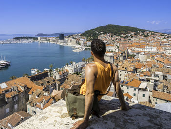 High angle view of tourist sitting on building terrace against city