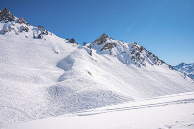 Ski tracks on snowy mountain range in alps
