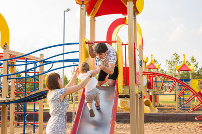 Rear view of people standing in playground