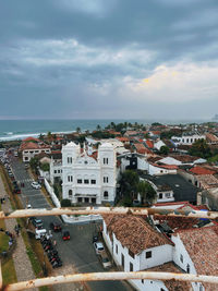 High angle view of townscape by sea against sky