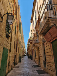 Low angle view of narrow alley amidst buildings in city