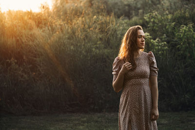 Rear view of woman standing against trees