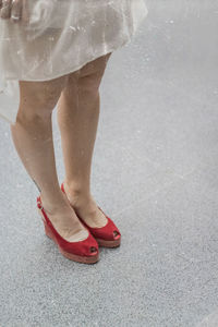 Low section of woman standing on footpath