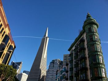 Low angle view of skyscrapers against blue sky