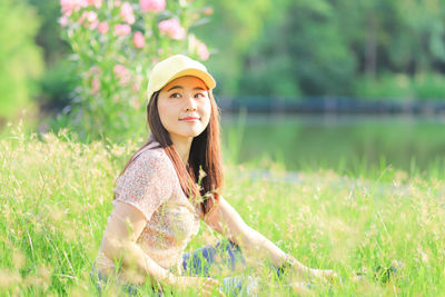 Portrait of young woman wearing hat on field