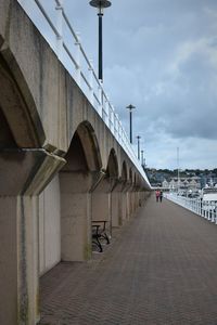 Bridge over road in city against sky