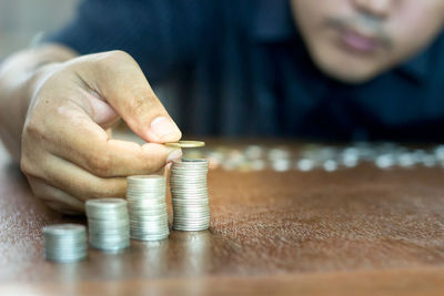 Midsection of mid adult woman stacking coins on table