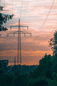 High voltage towers at sunset with trees