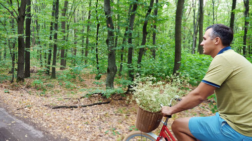 A man riding a bicycle in the forest, in the summer