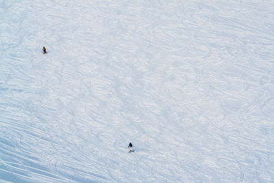 High angle view of people skiing on snow-covered field