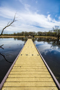 Pier over lake against sky