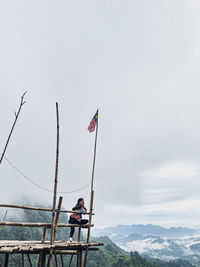 Low angle view of a girl alone on hanging hut with skies full of clouds smiling