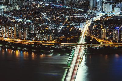 Illuminated bridge over river at night