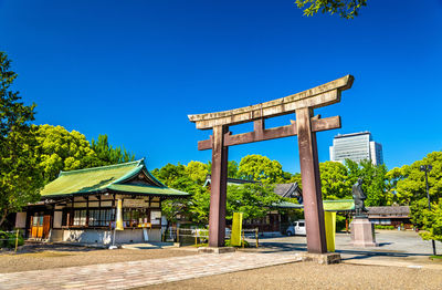 Gazebo by building against clear blue sky