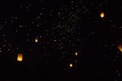 Low angle view of illuminated lights against sky at night