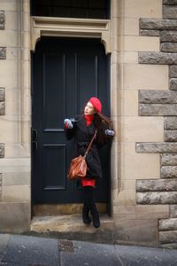 Full length of woman standing against building