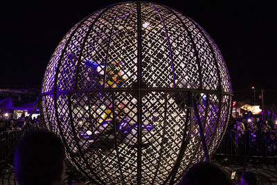 Illuminated ferris wheel against sky at night