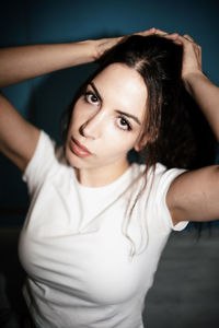 Portrait of young woman looking away against black background