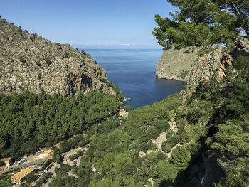 High angle view of sea by mountains against clear sky