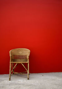 Wicker chair against red wall