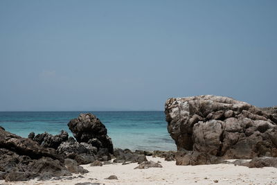 Rocks on beach against clear sky